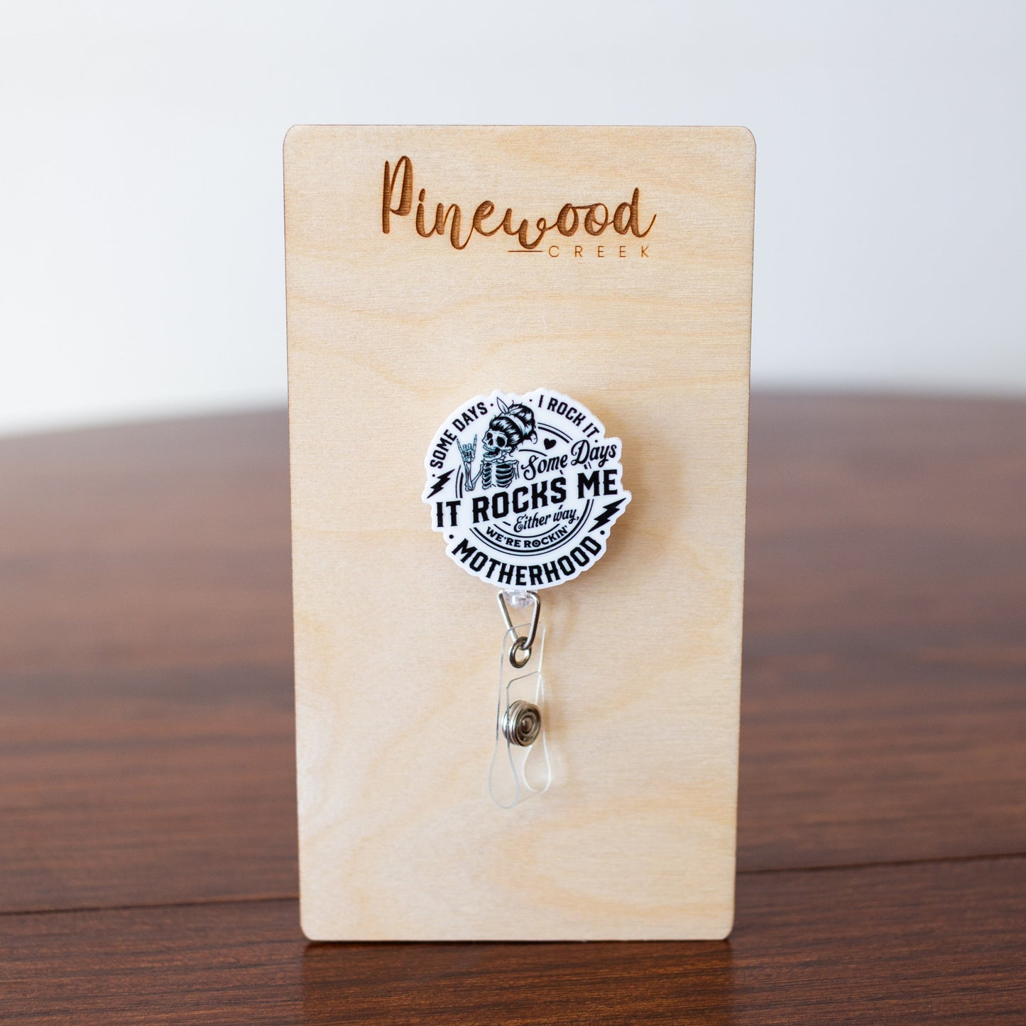 Motherhood Some Days I Rock It Some Days It Rocks Me Skeleton Badge Reel